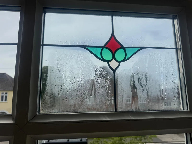 Misted stained-glass sealed unit with condensation trapped between the panes before replacement, Bristol