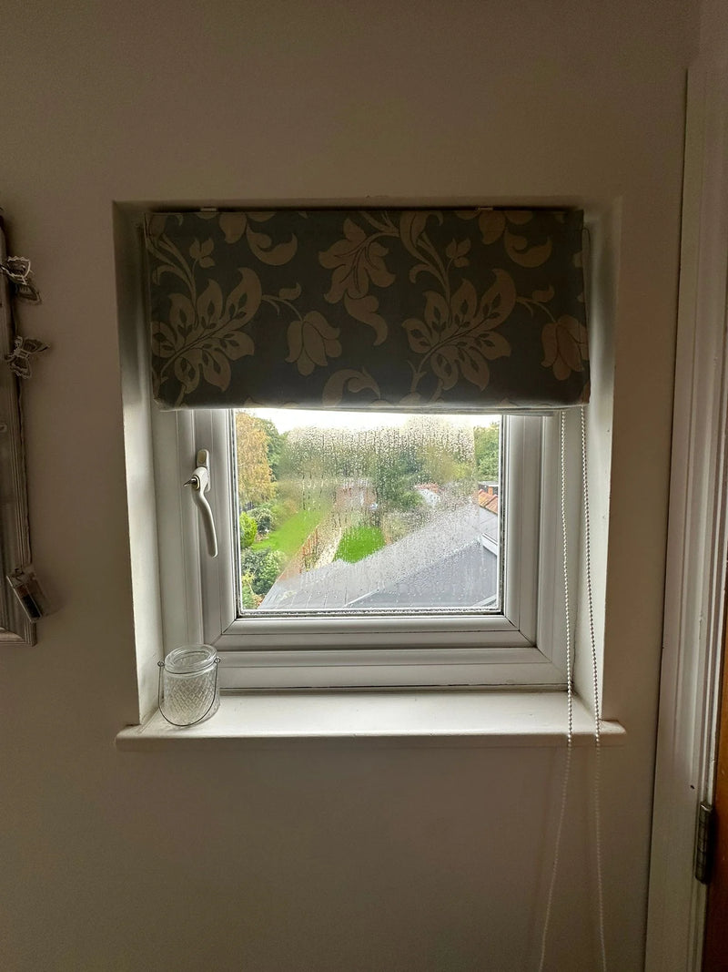 Condensation droplets trapped between double glazed panes in small casement window in Bristol