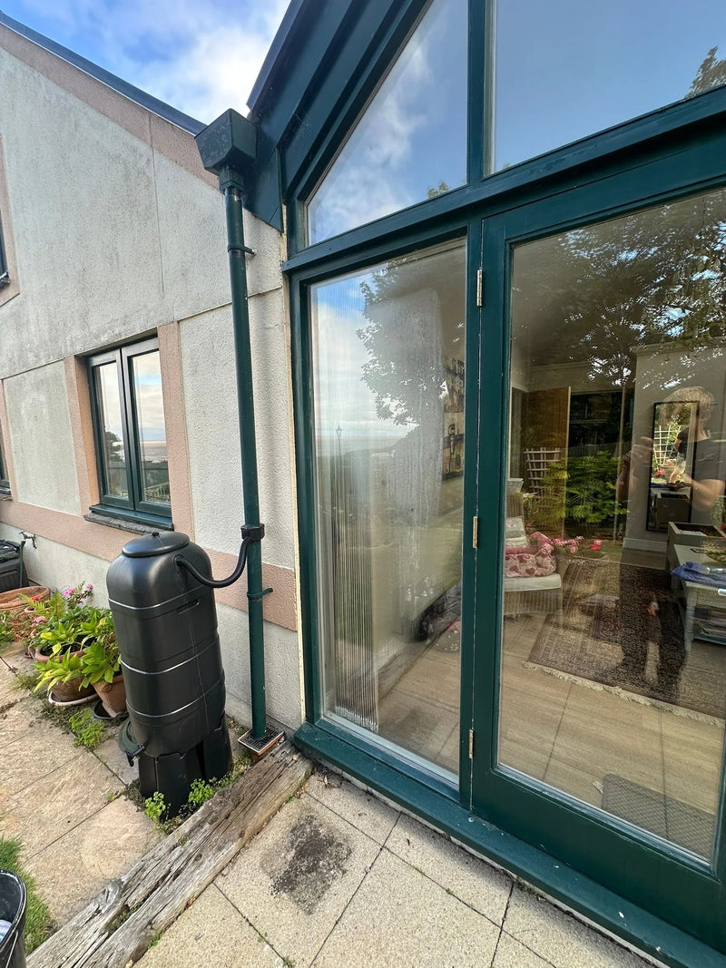 Conservatory patio doors with misted glass and green frame before repair in Bristol
