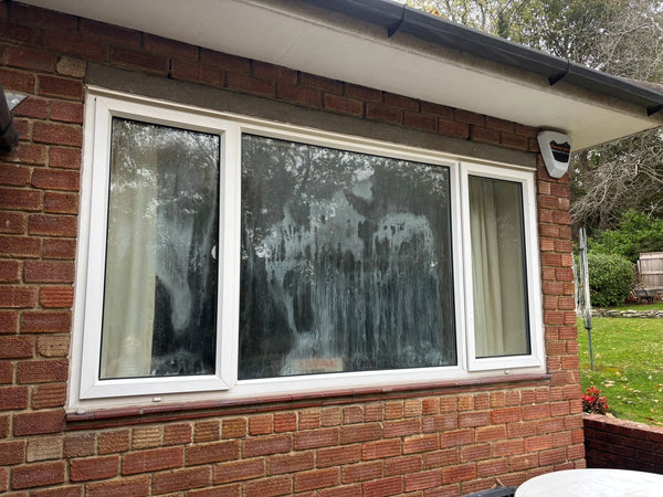 Exterior view of three-pane window with all double glazed units misted and failed in Bristol