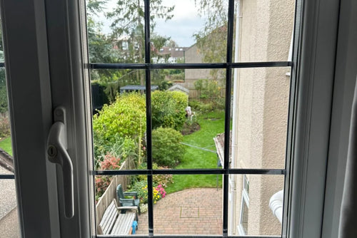 Georgian casement window repaired with clear glass and garden view in Bristol