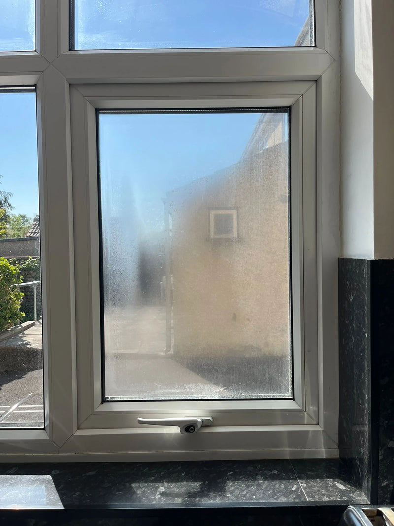 Misty kitchen window with condensation from failed double glazing in Bristol